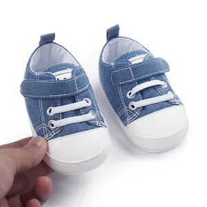 Gros plan de baskets en toile denim bleu pour bébé avec bride velcro