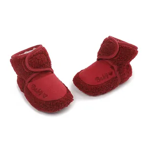 Detail view of red fleece-lined baby boots with heart embroidery and velcro strap