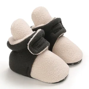 Close-up of cozy black and cream baby winter fleece booties with soft soles and Velcro