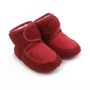 Red sherpa baby booties with 'Baby' embroidery and warm fleece lining for infants