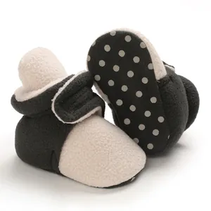 Close-up of soft fleece baby boots with anti-slip dotted sole for winter warmth.