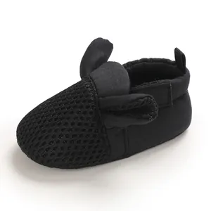 Dettaglio delle scarpe da neonato in mesh nero con simpatico design a orecchie di coniglio