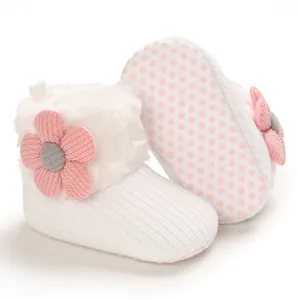 White infant winter snow boots featuring a pink flower detail and a soft non-slip sole