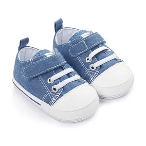 Vue détaillée de chaussures de marche bébé en denim bleu avec bout blanc souple