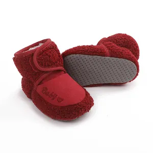 Detail of red baby winter boots showing soft non-slip sole and fuzzy texture