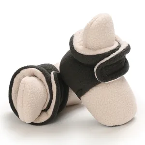 Close-up of soft fleece baby booties with adjustable hook and loop strap for winter