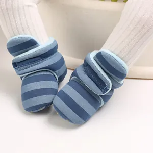 Nahaufnahme der blau gestreiften warmen Baby-Stiefeletten mit weicher Sohle für den Winter.