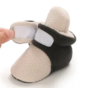 Macro detail of baby winter fleece bootie showing the adjustable velcro strap closure