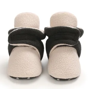 Macro view of cozy fleece texture on color-block infant winter booties with soft soles