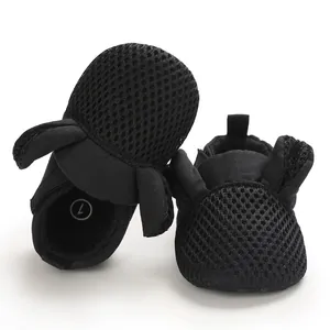 Primo piano del tessuto a rete nero traspirante e del design a orecchie per scarpe bebè