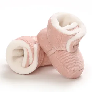 Gros plan de bottes de neige roses en velours côtelé pour bébé avec doublure polaire