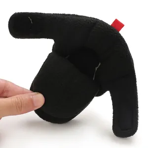 Primo piano del morbido tessuto in pile e del cinturino in velcro sugli stivaletti neri neonato.
