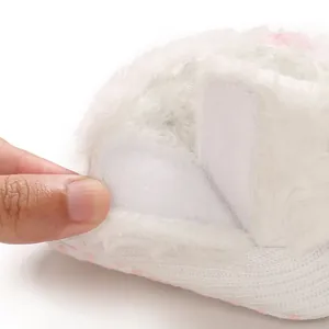Detailed view of the convenient Velcro closure on plush white fleece baby snow boots