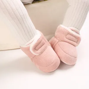 Détail de bottes roses pour bébé en velours côtelé avec doublure chaude en polaire.