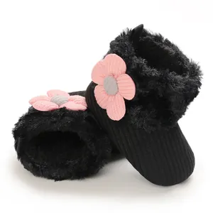 Detailed view of black fleece-lined infant snow boots featuring a pink knit flower