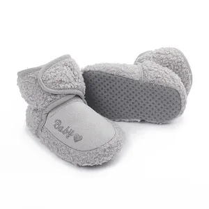 Close-up detail of grey baby fleece winter boots featuring anti-slip soles and baby embroidery