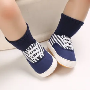 Vue détaillée de chaussures de bébé rayées bleu marine avec semelles souples