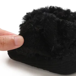 Close-up view of black plush baby winter snow boots featuring soft fleece lining and texture