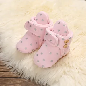 Primer plano de botas de nieve rosa para bebé con estrellas de plata y forro de felpa suave
