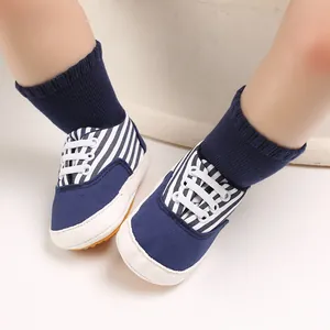 Gros plan de chaussures de marche pour bébé à rayures bleues et blanches et semelles souples
