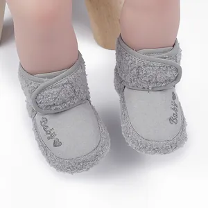Detail of grey baby fleece boots with velcro strap and embroidered heart design.