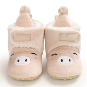 Détail rapproché de bottes de neige pour bébé fourrées avec motif de cochon mignon