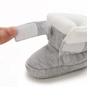 Detailweergave van grijze babybootie met witte fleecevoering en klittenbandsluiting.