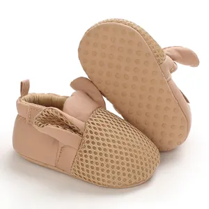 Dettaglio scarpe neonato in mesh traspirante con orecchie di coniglio e suola