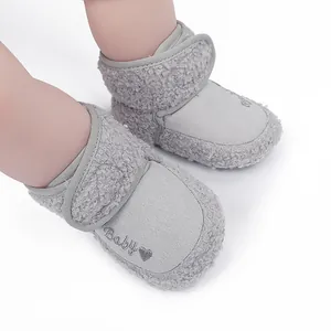 Detail view of grey baby winter boots with "Baby" embroidery and fuzzy trim.