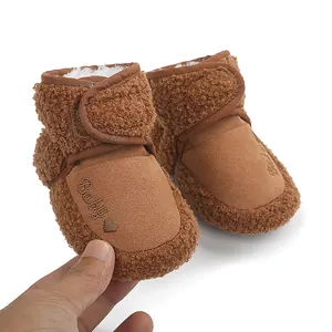 Close-up of brown plush baby winter boots with heart embroidery