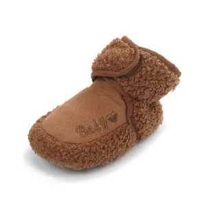 Detailed view of brown teddy fleece baby bootie with embroidered Baby text and heart