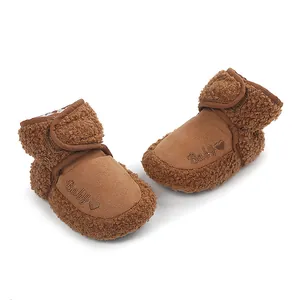 Close-up of brown plush baby boots with 'Baby' heart embroidery for winter.