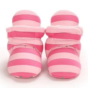 Nahaufnahme von rosa gestreiften, warmen Baby-Winterstiefeln mit weichen Sohlen