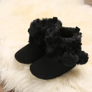 Cozy black infant booties with soft faux fur trim and pom-poms for baby girls aged 0-1