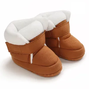 Close-up van bruine baby winterlaarzen met zachte witte fleece voering en klittenband