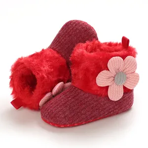 Detail of warm red baby winter boots with soft fur lining and decorative flower