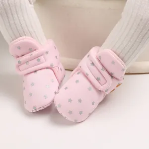 Primer plano de botas de nieve rosa para bebé con estrellas de plata y forro suave.