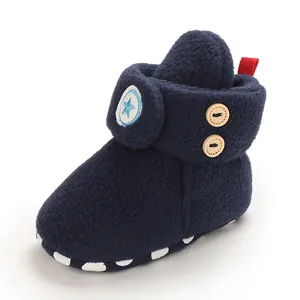 Detailweergave van zachte marineblauwe baby fleece laarsjes met ster en houten knopen.