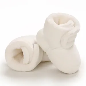 Gros plan de bottes de neige blanches en peluche pour bébé avec une doublure douce