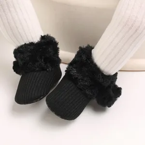 Detail view of black baby snow boots with soft faux fur trim and ribbed texture