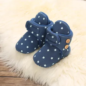 Vista detallada de botas de invierno para bebé con patrón de estrellas y forro polar.