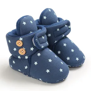 Primer plano de botas de nieve azules para bebé con estrellas y forro de vellón
