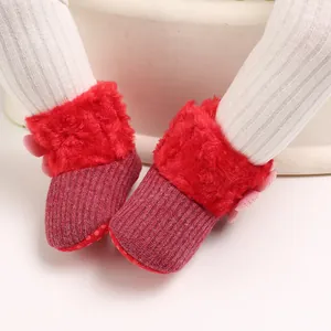 Detail view of red faux fur lined baby snow boots with soft non-slip soles and pink bow