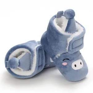 Vue détaillée des bottes de neige bleues pour bébé avec visage de porc et doublure douce.
