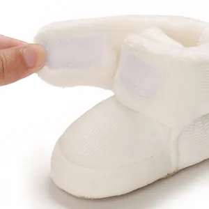 Gros plan de bottes de neige blanches pour bébé montrant le velcro et la doublure douce.