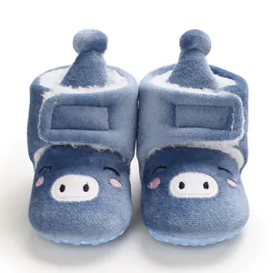 Gros plan de bottes bébé bleues avec visage de cochon brodé et doublure en polaire