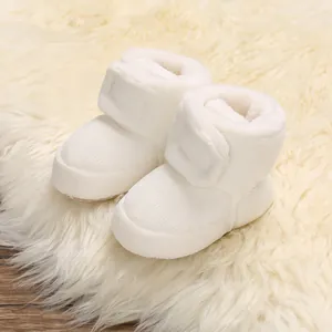 Bottines en peluche blanche pour bébé avec doublure chaude et fermeture à scratch.