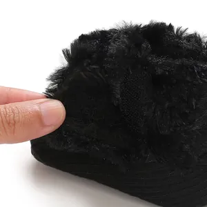 Close-up detail of black faux fur baby bootie featuring an adjustable Velcro strap closure