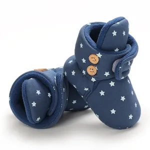 Detalle de botas de nieve para bebé azul marino con estampado de estrellas y forro suave