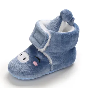 Vue détaillée de bottine bébé en peluche bleue avec motif cochon et doublure douce